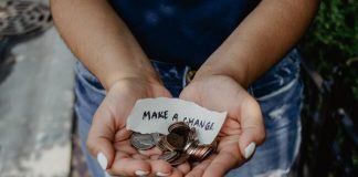 A person holds change and a strip of paper reading "Make a change"