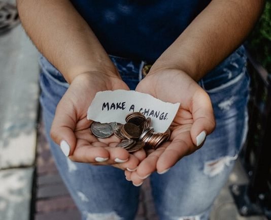 What Texting Software Is Best for Nonprofits? A person holds change and a strip of paper reading "Make a change"