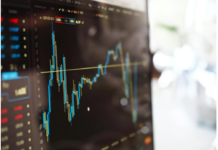 Person analyzing trading charts and account options on a laptop